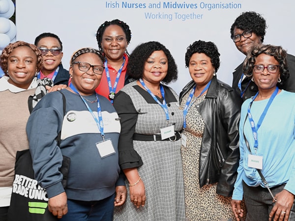 Group photo of International nurses at ADC standing in front of an INMO stand